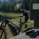 Randonnées VTT Lorraine près d’un lac, VTT et gants sur table