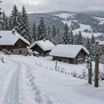 Le grand Valtin : chalets enneigés et panneau près d’une piste verte