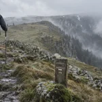 Randonnée Hohneck Vosges : randonneur sur crêtes par vent et brouillard
